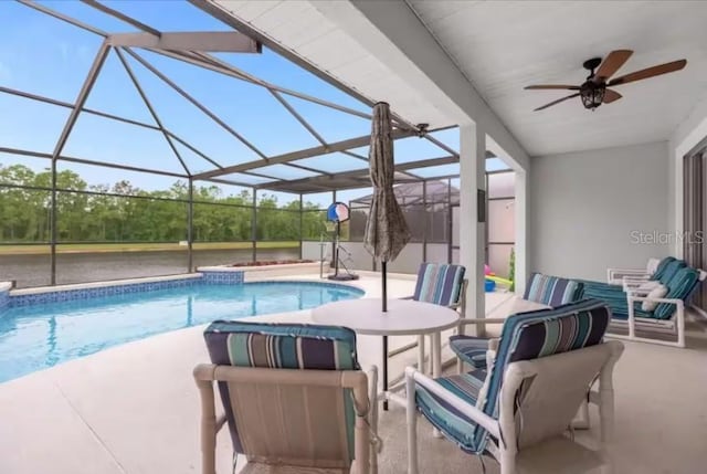 view of pool with ceiling fan, a patio area, and a lanai