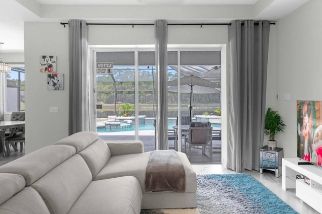 living room featuring a wealth of natural light and a notable chandelier