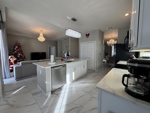 kitchen featuring stainless steel dishwasher, decorative light fixtures, a center island with sink, a notable chandelier, and white cabinetry