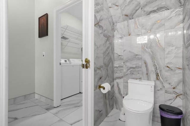 bathroom with washing machine and dryer and tile walls