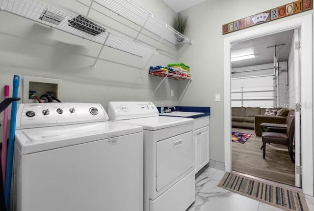 laundry area featuring separate washer and dryer and cabinets