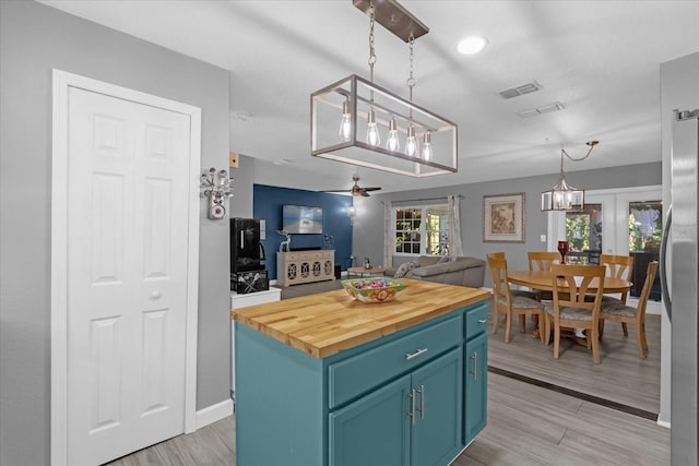 kitchen featuring ceiling fan, light hardwood / wood-style flooring, a kitchen island, and blue cabinets