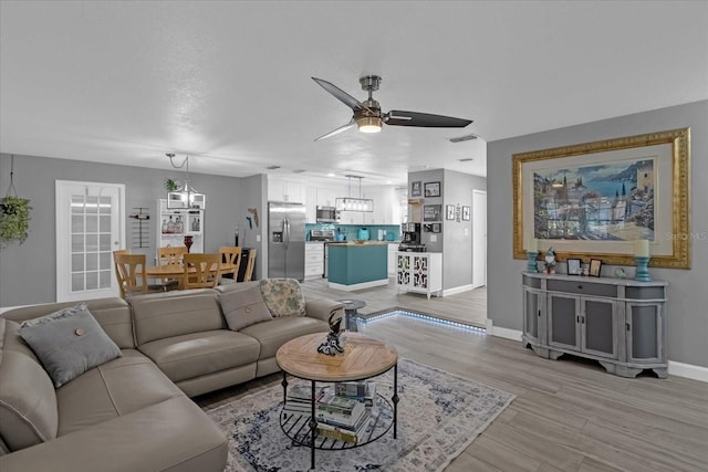 living room with ceiling fan and light hardwood / wood-style floors