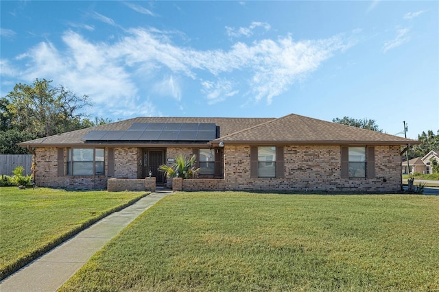 single story home featuring a front yard and solar panels