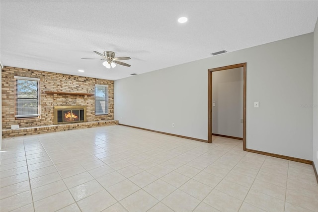 unfurnished living room with a fireplace, light tile patterned floors, and a textured ceiling