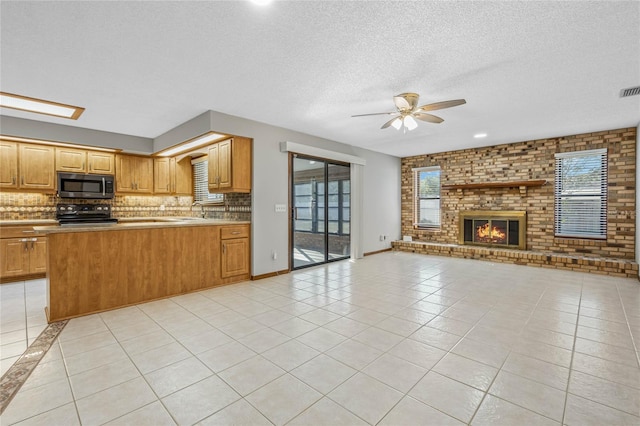 kitchen with black stove, backsplash, ceiling fan, light tile patterned floors, and a fireplace