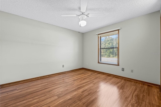 spare room featuring ceiling fan, wood-type flooring, and a textured ceiling