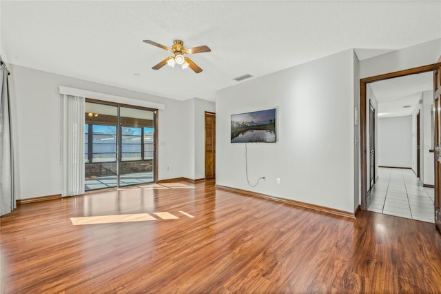 unfurnished living room with ceiling fan, a textured ceiling, and light hardwood / wood-style flooring