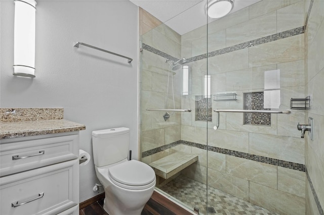 bathroom featuring walk in shower, hardwood / wood-style floors, vanity, and toilet