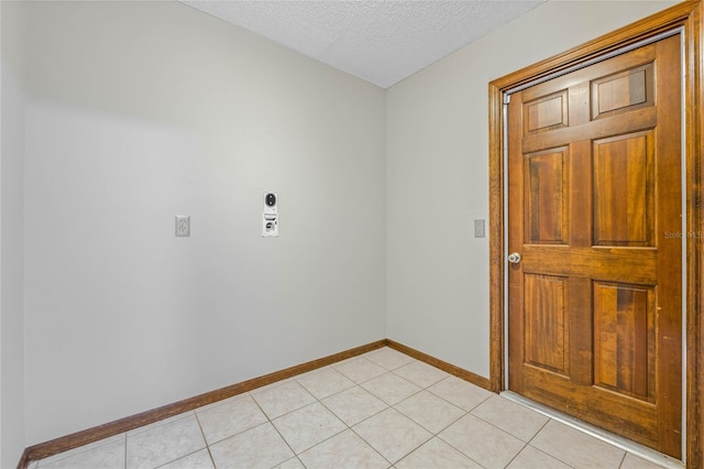 spare room featuring light tile patterned floors and a textured ceiling