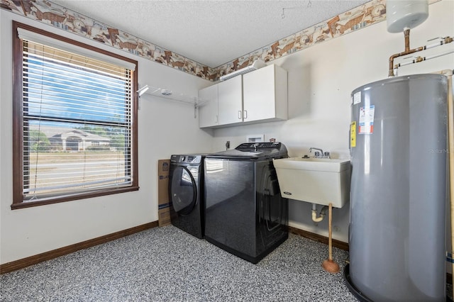 laundry area featuring cabinets, a textured ceiling, gas water heater, sink, and washing machine and dryer