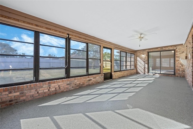 unfurnished sunroom with ceiling fan