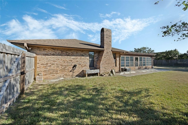 back of house with a yard and a patio