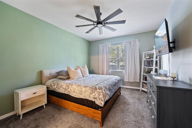 bedroom with ceiling fan, baseboards, dark colored carpet, and a textured ceiling