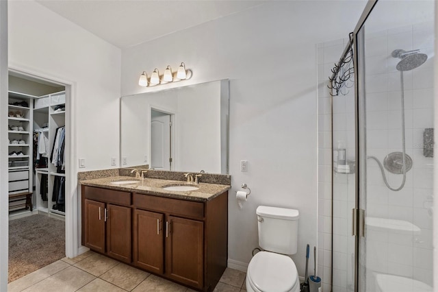 bathroom with tile patterned flooring, vanity, toilet, and walk in shower