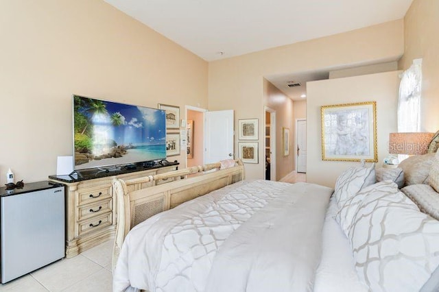 bedroom with fridge and light tile patterned flooring