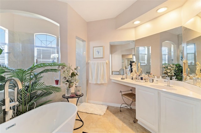 bathroom featuring tile patterned flooring, a bathing tub, and vanity