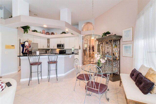 tiled dining room with high vaulted ceiling