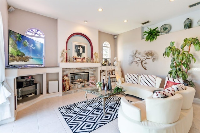 living room with light tile patterned floors and a fireplace