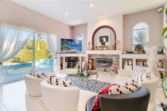 tiled living room with a stone fireplace and plenty of natural light