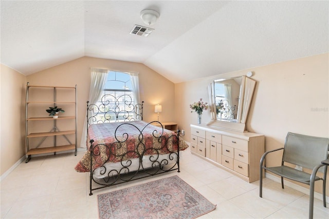 bedroom with lofted ceiling and light tile patterned floors