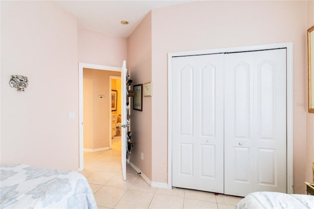 bedroom with light tile patterned floors and a closet