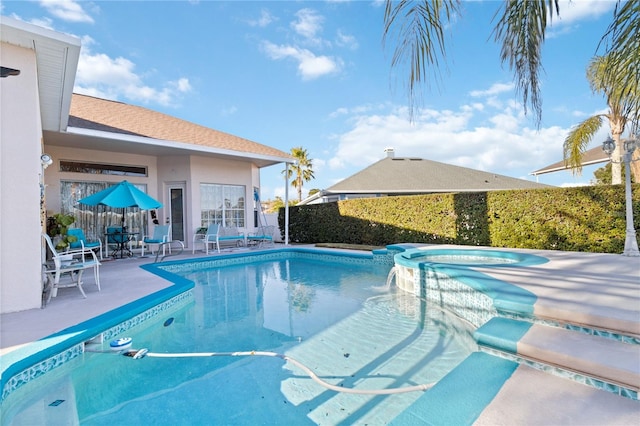 view of swimming pool with a patio area, pool water feature, and an in ground hot tub