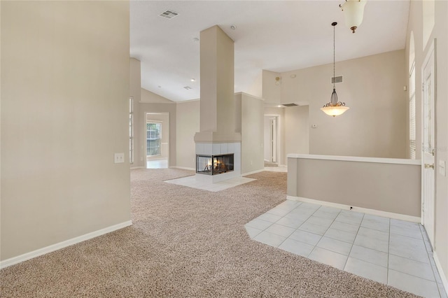 unfurnished living room with a multi sided fireplace, light colored carpet, and high vaulted ceiling