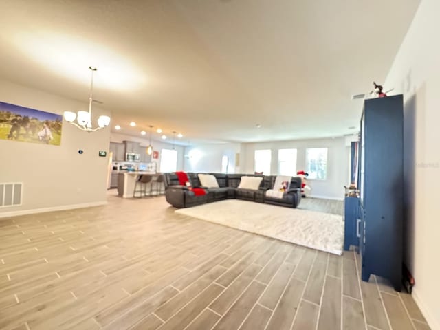 living room featuring light hardwood / wood-style flooring and a notable chandelier