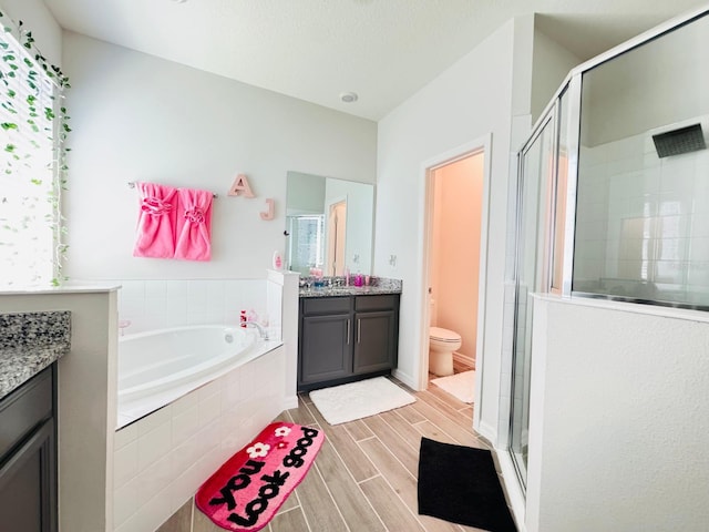 full bathroom featuring hardwood / wood-style flooring, vanity, toilet, and plus walk in shower