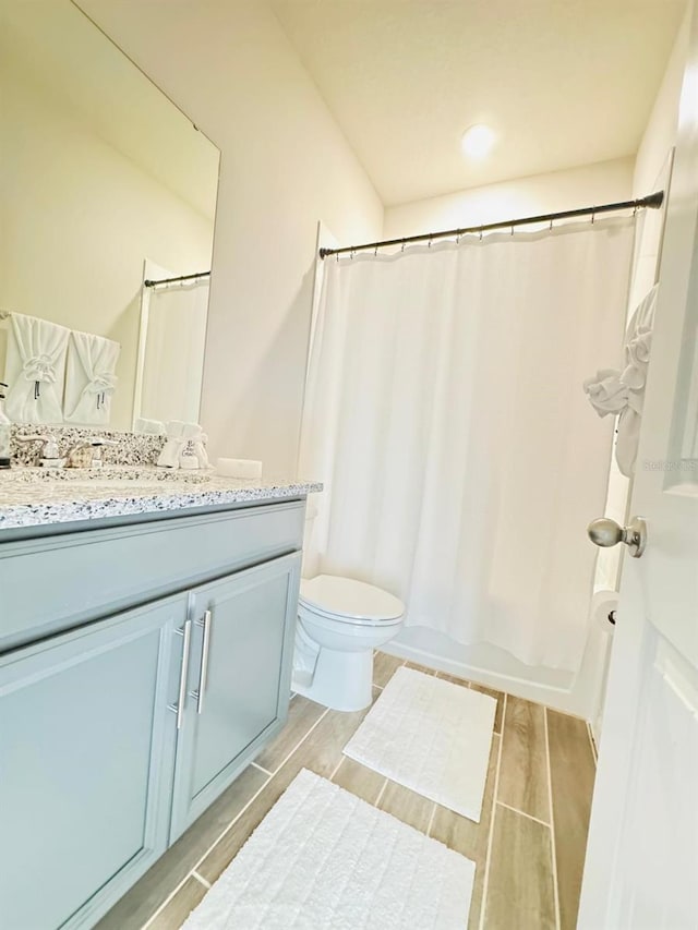 full bathroom with hardwood / wood-style floors, vanity, toilet, and shower / bath combo