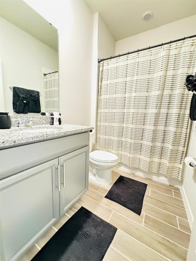 full bathroom with shower / bath combo with shower curtain, vanity, and toilet