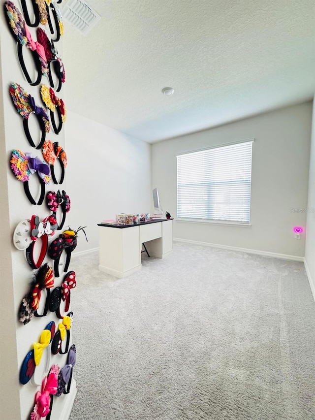 playroom with light carpet and a textured ceiling