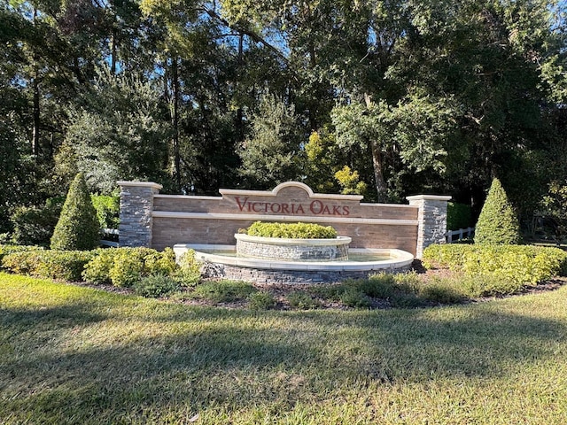 community sign featuring a yard