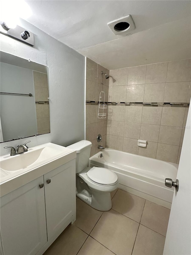 full bathroom with tile patterned flooring, vanity, tiled shower / bath combo, and toilet