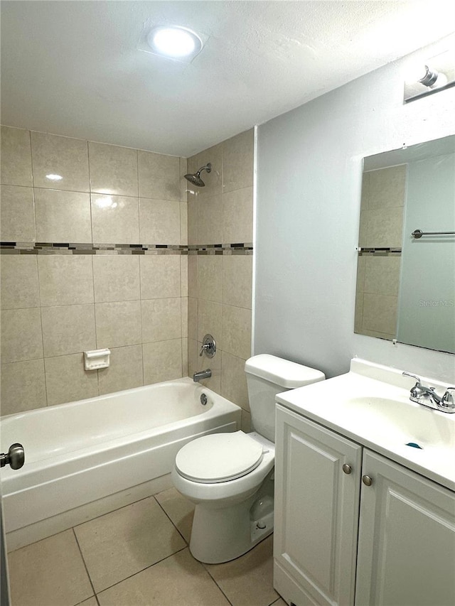 bathroom featuring tile patterned flooring, tub / shower combination, vanity, and toilet