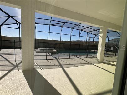 view of patio featuring glass enclosure