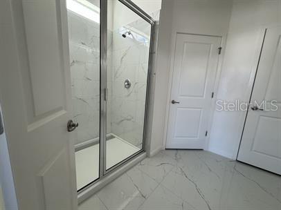 bathroom featuring a shower with door