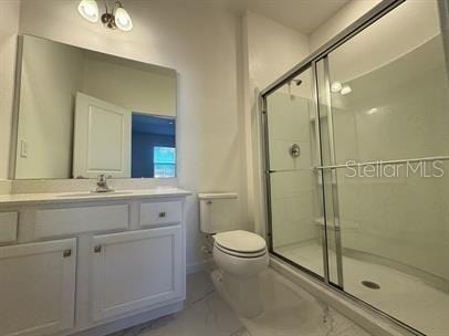 bathroom featuring walk in shower, vanity, and toilet