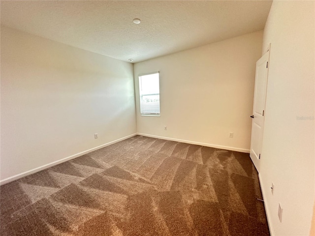 carpeted spare room featuring a textured ceiling