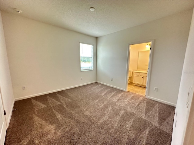 empty room with light carpet and a textured ceiling