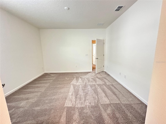 carpeted spare room with a textured ceiling