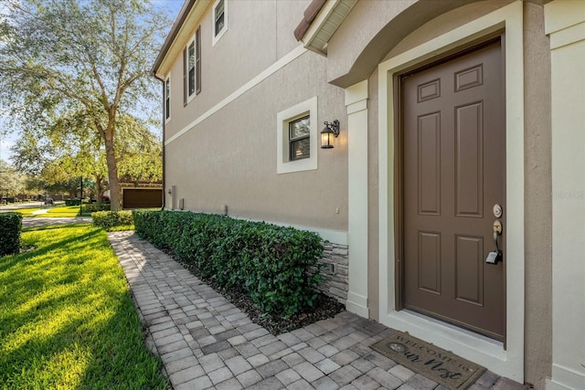 view of exterior entry with a yard