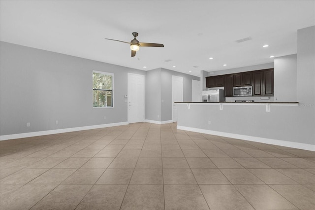 unfurnished living room featuring light tile patterned floors and ceiling fan