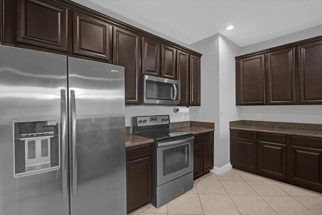 kitchen with dark brown cabinets, light tile patterned floors, and appliances with stainless steel finishes