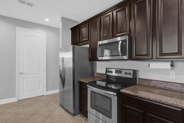 kitchen featuring dark brown cabinetry, light tile patterned floors, and appliances with stainless steel finishes