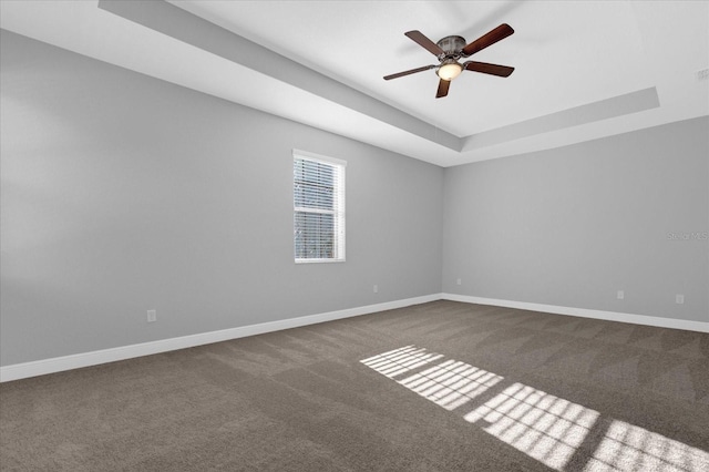 unfurnished room with carpet floors, a tray ceiling, and ceiling fan