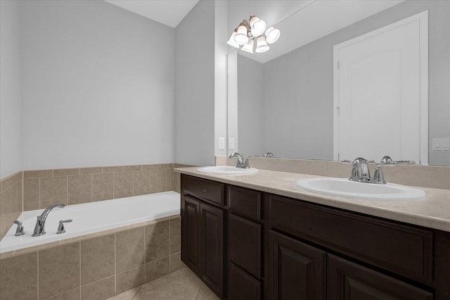 bathroom with tile patterned floors, vanity, and a relaxing tiled tub