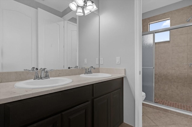 bathroom with tile patterned floors, vanity, toilet, and an enclosed shower