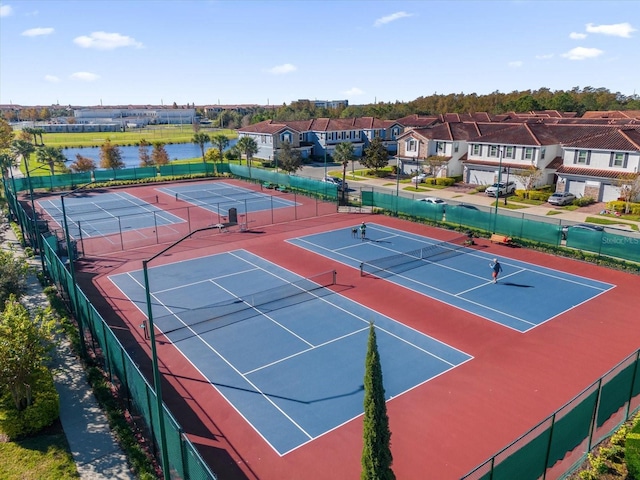 view of sport court with a water view and basketball hoop